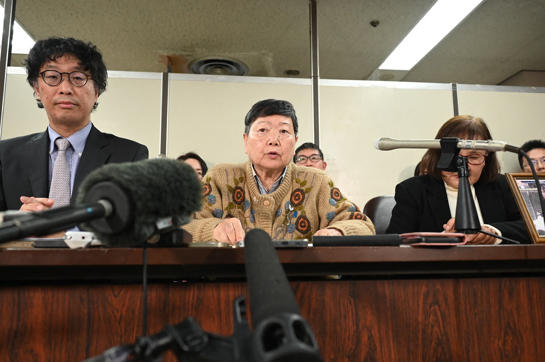 One of the plaintiffs Eiko Kawasaki (C) and chief lawyer Kenji Fukuda (L) hold a press conference in Tokyo on January 26, 2026, following a court ruling ordering the North Korean government to pay compensation over the repatriation program to North Korea. A Tokyo court ordered Pyongyang on January 26 to pay more than 500,000 USD in compensation to four people lured to North Korea by a fantastical propaganda scheme promising a "paradise on Earth". (Photo by JIJI Press / AFP via Getty Images) / Japan OUT
